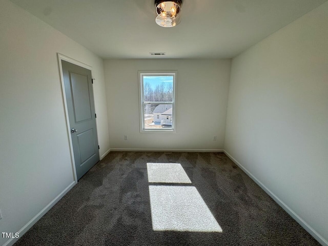 carpeted spare room with baseboards and visible vents