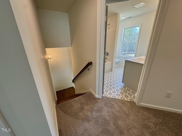 stairway with carpet floors, visible vents, and baseboards