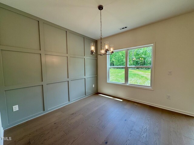 235 Grand Griffon Way, Lillington, NC 27546 - unfurnished dining area featuring a chandelier, wood finished floors, and baseboards