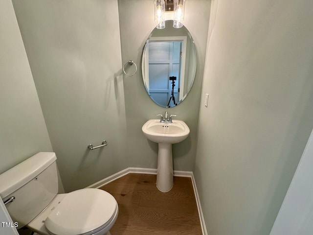235 Grand Griffon Way, Lillington, NC 27546 - half bathroom featuring toilet, wood finished floors, baseboards, and a sink
