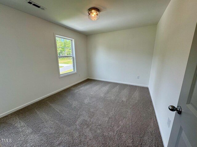 235 Grand Griffon Way, Lillington, NC 27546 - spare room featuring dark carpet and baseboards