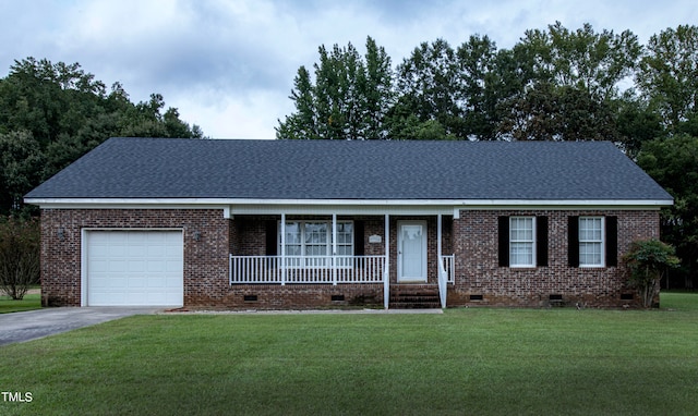 ranch-style home featuring a garage, covered porch, and a front lawn