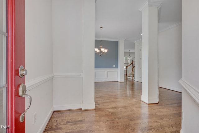 foyer featuring hardwood / wood-style floors, ceiling fan with notable chandelier, and crown molding