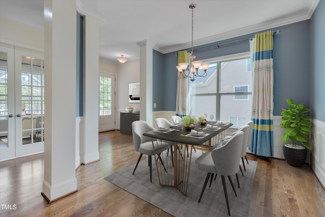 dining room with wood-type flooring, crown molding, and french doors