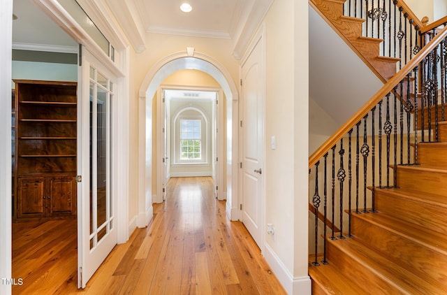 hallway with crown molding and light wood-type flooring