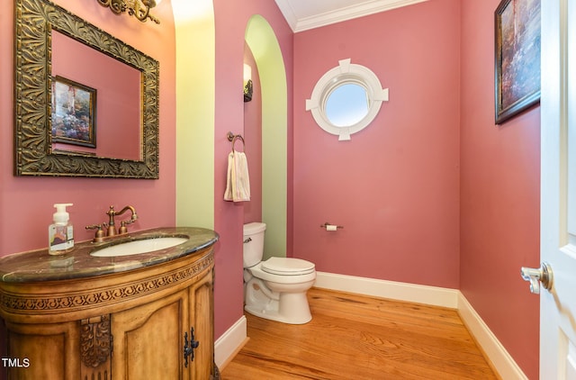 bathroom with hardwood / wood-style floors, vanity, toilet, and crown molding
