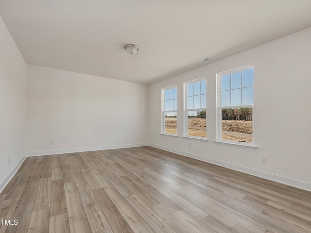 empty room with light wood-style floors and baseboards