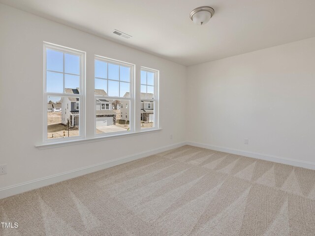 empty room featuring carpet and baseboards