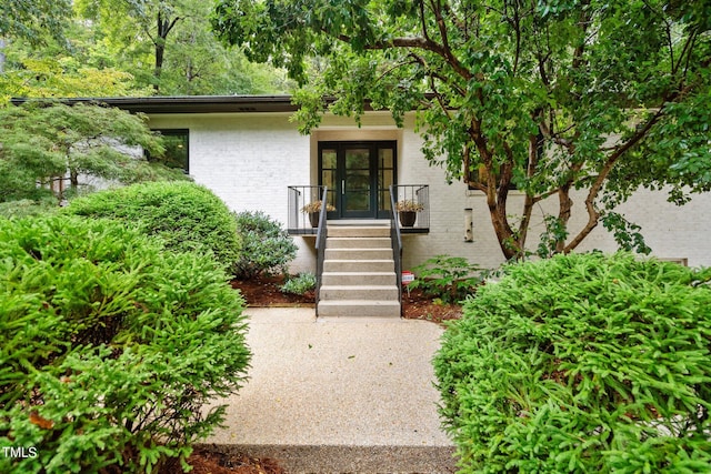 view of exterior entry with french doors and brick siding