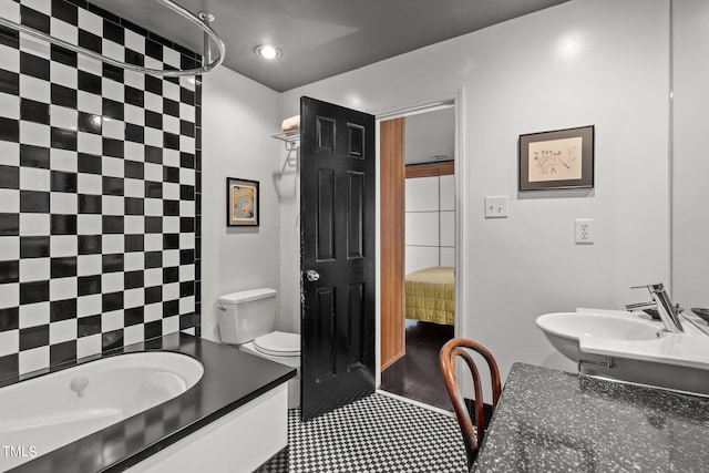 bathroom featuring sink, a shower, tile patterned floors, tile walls, and toilet