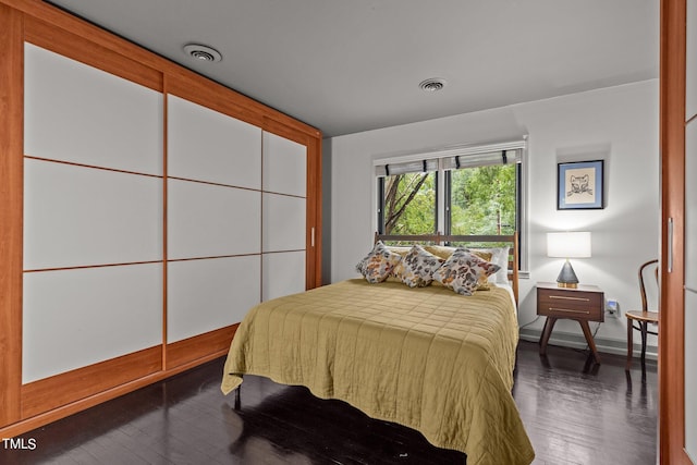 bedroom with dark wood-type flooring