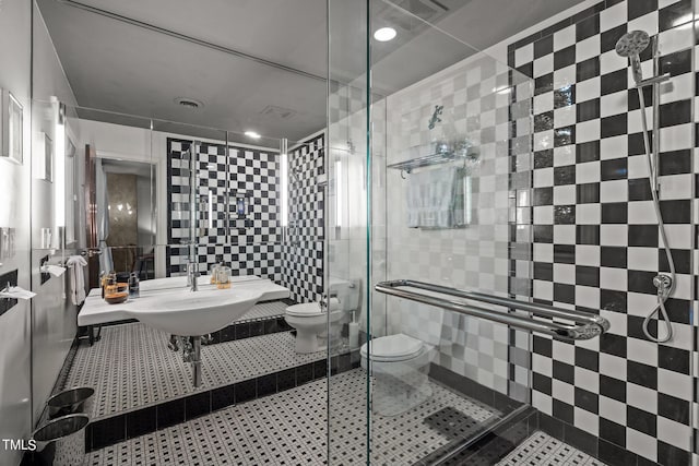 bathroom with visible vents, tile walls, toilet, tile patterned floors, and a stall shower