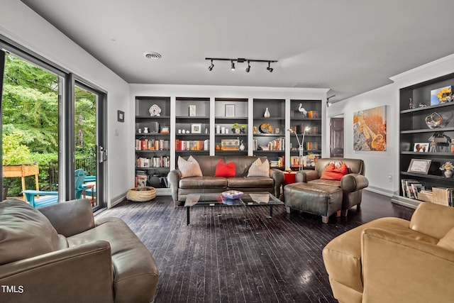 living area with built in shelves, visible vents, baseboards, and wood finished floors