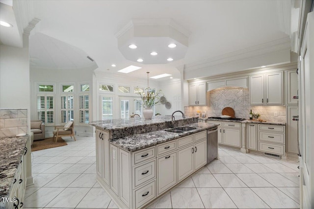 kitchen featuring an island with sink, appliances with stainless steel finishes, ornamental molding, and sink