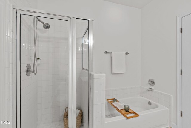 bathroom featuring shower with separate bathtub