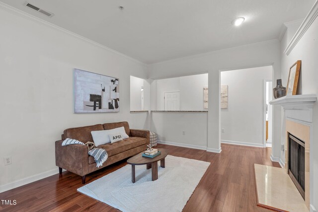 living room with ornamental molding, a high end fireplace, and hardwood / wood-style flooring