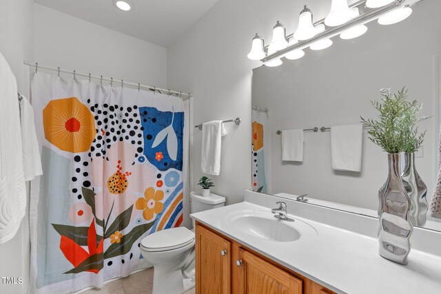 bathroom featuring curtained shower, vanity, toilet, and tile patterned floors