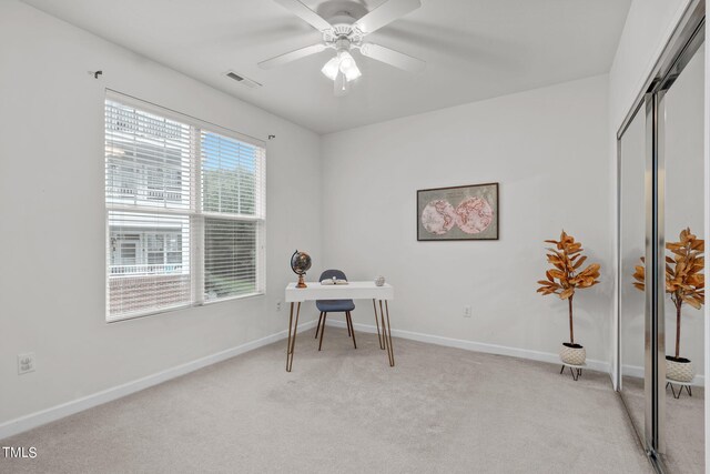 carpeted home office with ceiling fan