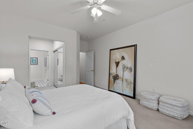 bedroom featuring ensuite bath, ceiling fan, and light colored carpet