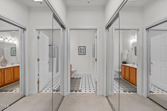 bathroom featuring vanity, toilet, and a shower with shower door