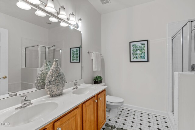 bathroom featuring vanity, toilet, and a shower with door