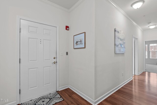 foyer entrance with ornamental molding and dark hardwood / wood-style floors