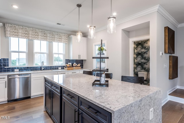 kitchen with white cabinets, dishwasher, a center island, and plenty of natural light