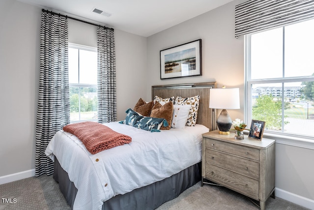 bedroom featuring light carpet and multiple windows