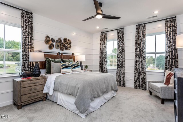 carpeted bedroom with ceiling fan and multiple windows