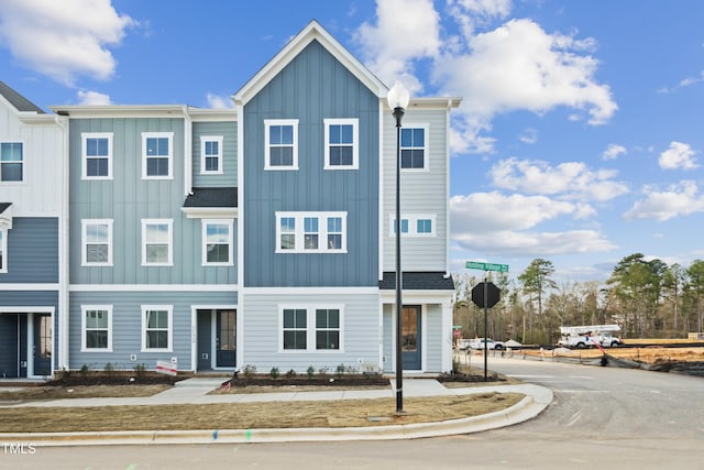 townhome / multi-family property featuring roof with shingles and board and batten siding