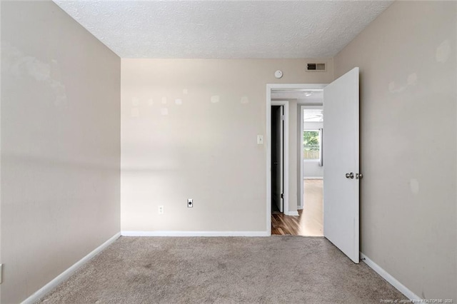 empty room with carpet and a textured ceiling