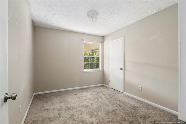 unfurnished room featuring light carpet and a textured ceiling