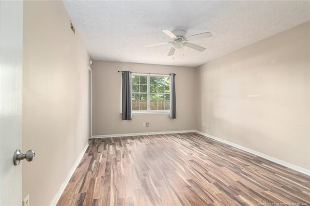 spare room with hardwood / wood-style floors, ceiling fan, and a textured ceiling