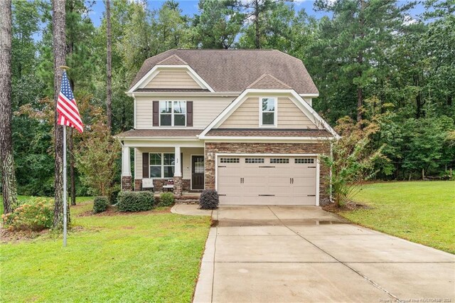 craftsman house with a garage, a front lawn, and covered porch