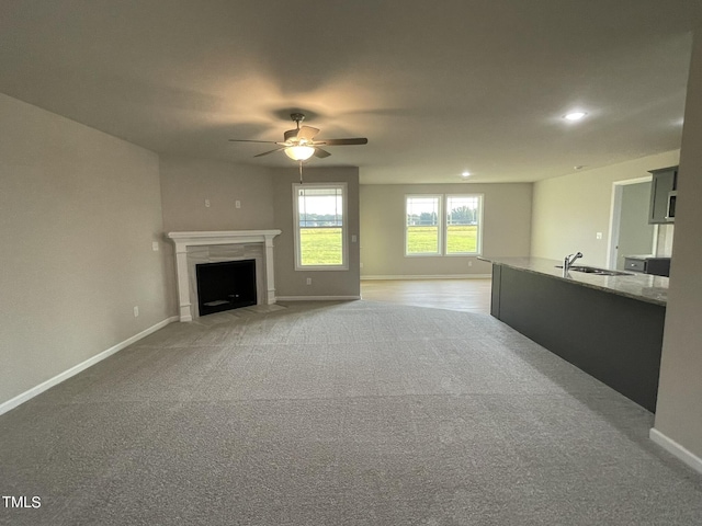 53 Grace Ridge Ct, Benson, NC 27504 - unfurnished living room featuring ceiling fan, light colored carpet, recessed lighting, baseboards, and a fireplace with flush hearth