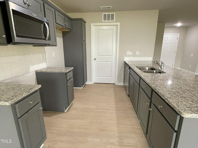 53 Grace Ridge Ct, Benson, NC 27504 - kitchen featuring visible vents, a peninsula, light stone counters, a sink, and appliances with stainless steel finishes
