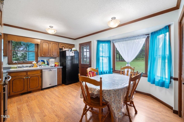 dining room with a textured ceiling, light hardwood / wood-style flooring, and a healthy amount of sunlight