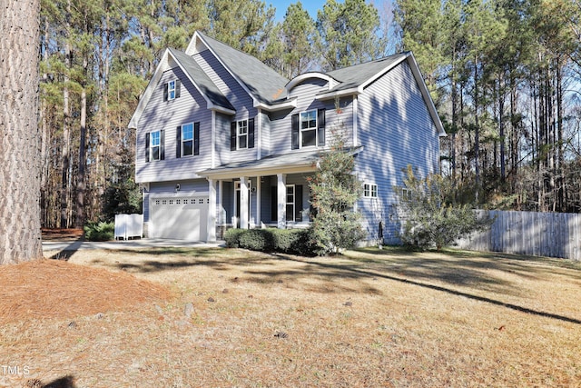 view of property featuring a front yard, a porch, and a garage