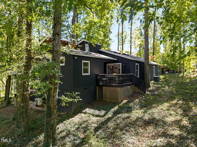 rear view of property featuring central AC unit and a wooden deck