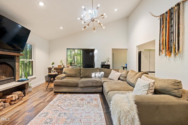 living room featuring a chandelier, light hardwood / wood-style floors, and high vaulted ceiling