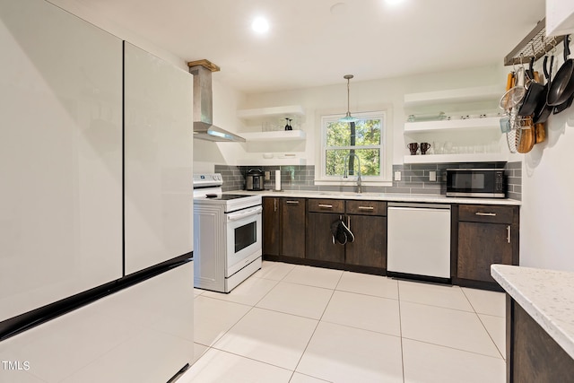 kitchen featuring wall chimney exhaust hood, white appliances, hanging light fixtures, and dark brown cabinetry