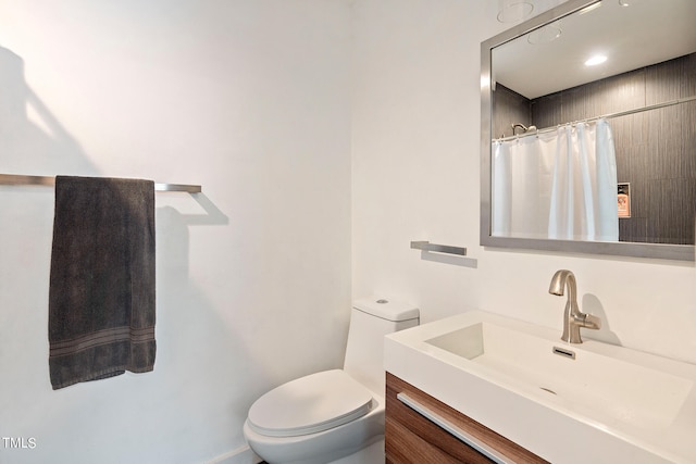 bathroom featuring vanity, toilet, and curtained shower