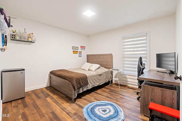 bedroom featuring stainless steel refrigerator and dark hardwood / wood-style floors