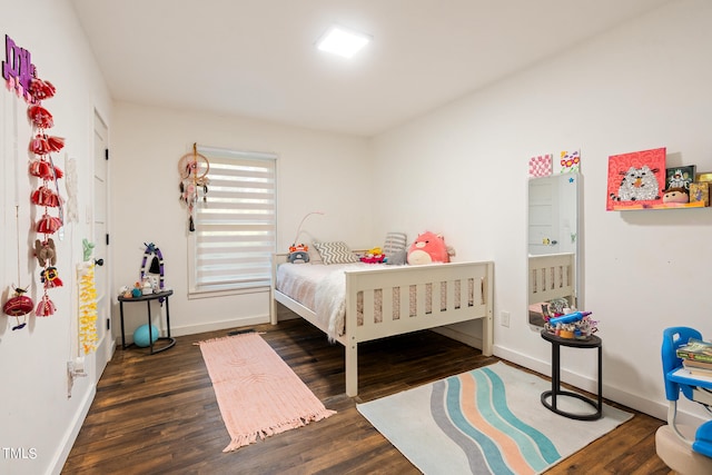 bedroom with dark hardwood / wood-style floors