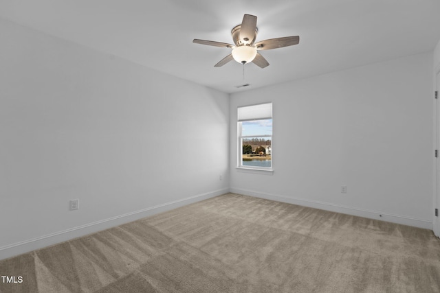 empty room featuring ceiling fan, light carpet, and baseboards