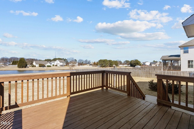 wooden deck with a residential view, fence, and a water view