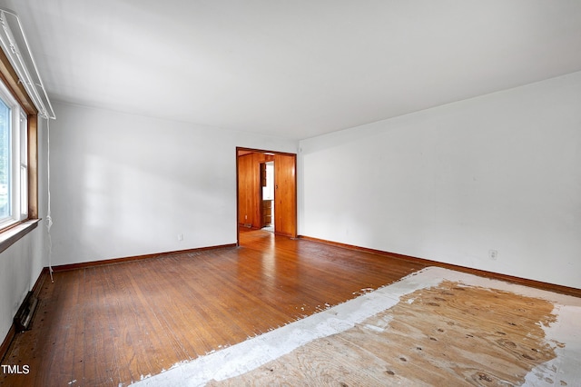 unfurnished room with hardwood / wood-style flooring and baseboards