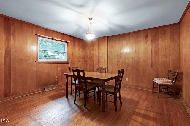 dining area with ornamental molding, wood-type flooring, and visible vents