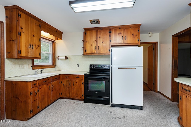 kitchen with brown cabinetry, freestanding refrigerator, and black range with electric cooktop