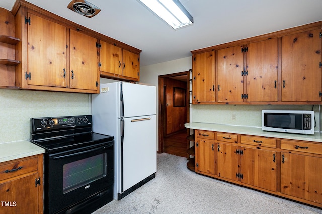 kitchen with freestanding refrigerator, brown cabinets, black / electric stove, and open shelves